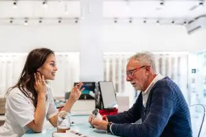 Person shopping for hearing aids at a hearing care store and exploring available hearing aid options.