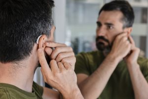 An emotional person wearing a hearing aid for the first time, reacting with a joyful expression.